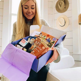 Woman smiling holding Authentic Books box